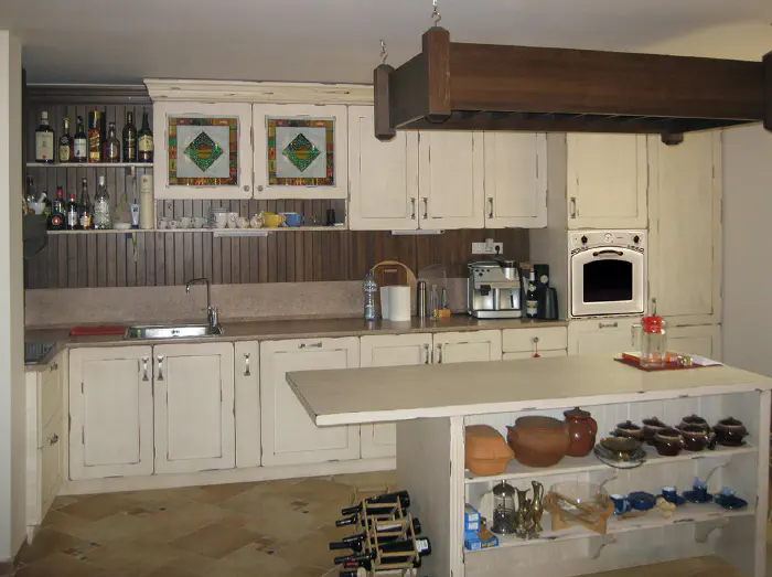 Kitchen with glass painting – aged kitchen with an island, panelling, painted glass and a hanging pan rack, photo 1